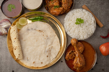 Kolhapuri chicken Thali is a popular Indian asian food platter consists of poultry meat, chikan sukka bhakri, rice, salad tambda padhra rassa 