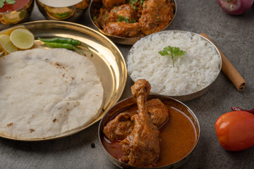 Kolhapuri chicken Thali is a popular Indian asian food platter consists of poultry meat, chikan sukka bhakri, rice, salad tambda padhra rassa 