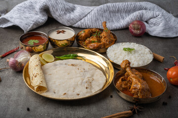Kolhapuri chicken Thali is a popular Indian asian food platter consists of poultry meat, chikan sukka bhakri, rice, salad tambda padhra rassa 