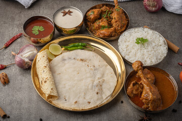 Kolhapuri chicken Thali is a popular Indian asian food platter consists of poultry meat, chikan sukka bhakri, rice, salad tambda padhra rassa 