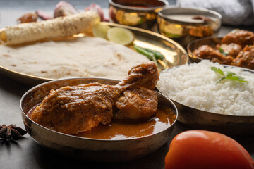 Kolhapuri chicken Thali is a popular Indian asian food platter consists of poultry meat, chikan sukka bhakri, rice, salad tambda padhra rassa 