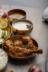 Kolhapuri chicken Thali is a popular Indian asian food platter consists of poultry meat, chikan sukka bhakri, rice, salad tambda padhra rassa 