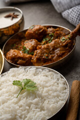 Kolhapuri chicken Thali is a popular Indian asian food platter consists of poultry meat, chikan sukka bhakri, rice, salad tambda padhra rassa 