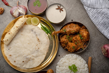 Kolhapuri chicken Thali is a popular Indian asian food platter consists of poultry meat, chikan sukka bhakri, rice, salad tambda padhra rassa 