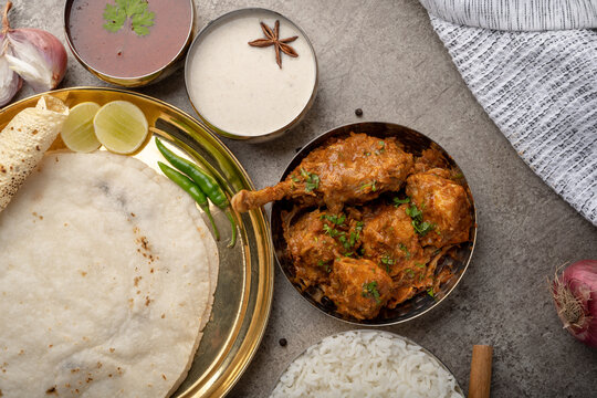 Kolhapuri chicken Thali is a popular Indian asian food platter consists of poultry meat, chikan sukka bhakri, rice, salad tambda padhra rassa 