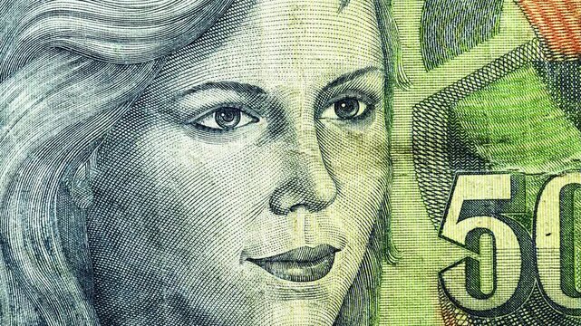 Close pan of Yugoslav 50000 dinar note showing female portrait and crest emblem