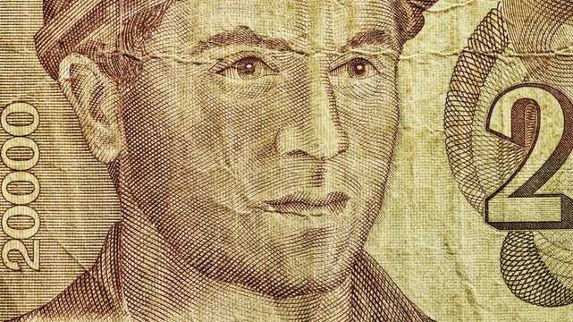 Macro pan of 20000 dinar banknote showing portrait with heavy creases and worn paper