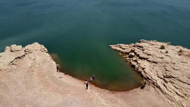 Top drone shot of group of people enjoying at sea water during sunny noon near HUB dam in Balochistan, Pakistan.