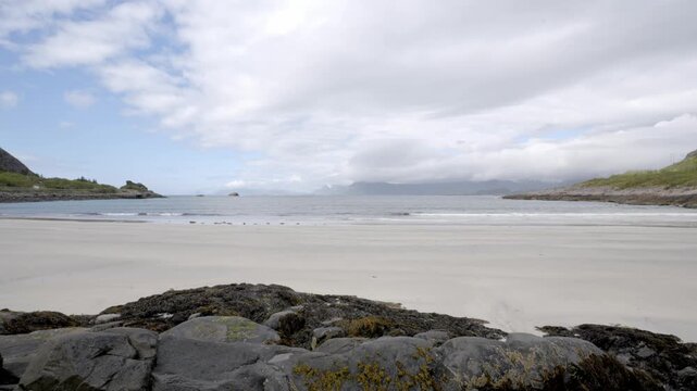 Static view from tripod looking out on Rorvik Beach in Lofoten, Norway, waves breaking gently on sandy shore.