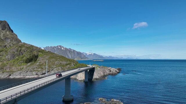 Light traffic driving across Djupfjord Bridge on E10 highway south of Reine toward Moskenes in Lofoten, Norway.