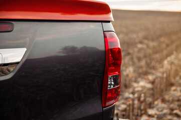 Tail light of grey pickup truck. Close-up view of rear part of pickup truck: tail gate and orange bed cover.  © andrbk