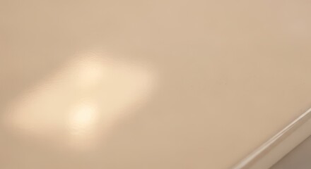 Light reflection on clean, plain beige surface. Soft, subtle background.