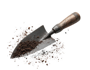 Dark metal trowel, edged with soil, rests on a bed of dirt