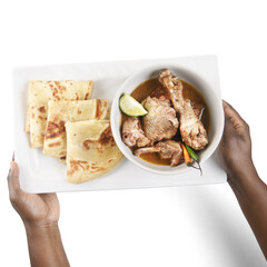 hand holding a plate of food with paratha