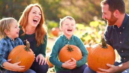 Happy family enjoying a sunny autumn day at a pumpkin patch, laughing and holding their freshly picked pumpkins. Perfect for fall, Halloween, and family fun concepts.