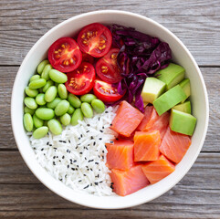 Poke bowl with rice, salmon, avocado, red cabbage, edamame and tomatoes. Healthy food. Diet.