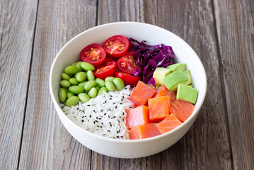 Poke bowl with rice, salmon, avocado, red cabbage, edamame and tomatoes. Healthy food. Diet.
