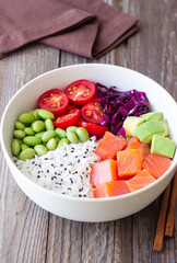 Poke bowl with rice, salmon, avocado, red cabbage, edamame and tomatoes. Healthy food. Diet.