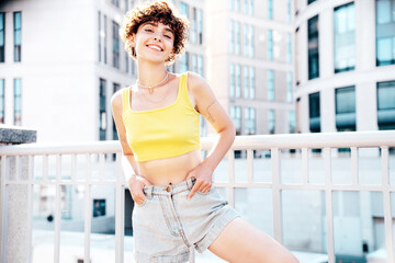 Young beautiful smiling hipster woman in trendy summer clothes. Carefree woman with curls...