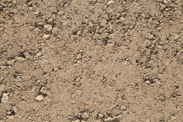 Brown fresh pressed sand and gravel country road background. Closeup. Top down view.