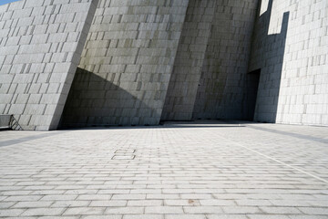 Fototapeta premium Modern building space with stone walls and paved ground