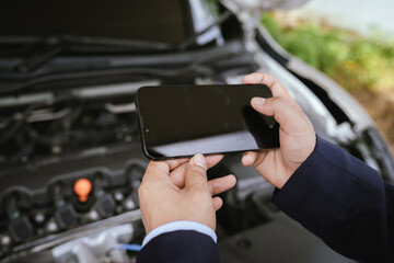 A professional inspects a car engine with documents and pen, symbolizing insurance, claim assessment, automotive inspection, legal contract, and vehicle evaluation.