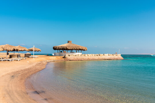 Sunny beach with thatched umbrellas in Hurghada