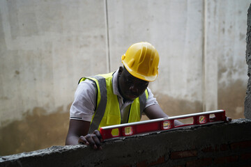 Construction worker using level tool to ensure accuracy in building project
