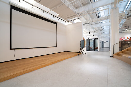 Modern office space with projection screen and tiered seating