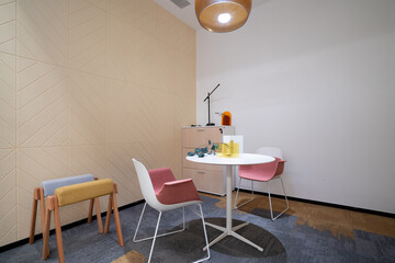 Cozy small room with table, colorful chairs and a lamp