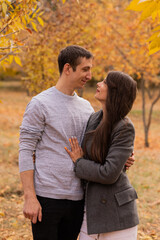 Fototapeta premium Loving couple hugging each other in an autumn park. autumn mood, autumn concept, fall. Husband and wife, groom and bride, dad and mom