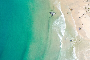 A top down aerial view of a clear turquoise ocean and a sandy beach The Essence of Serenity