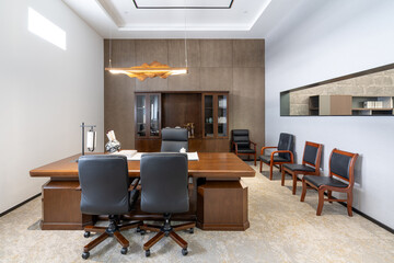 Formal office with wooden desk, chairs and cabinetry