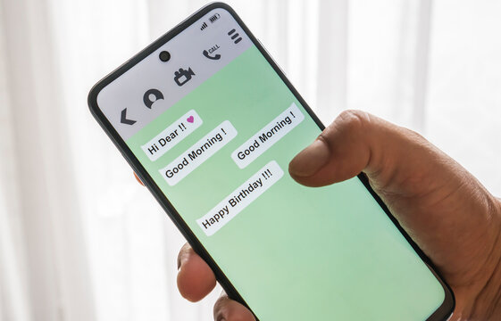 man holding a smartphone. Messaging app open with the message: happy birthday