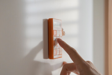 A woman uses a kitchen timer attached to the refrigerator.　冷蔵庫に取り付けられたキッチンタイマーを使う女性