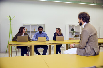 Group Discussion in a Contemporary Office Setting with Laptops and Collaboration