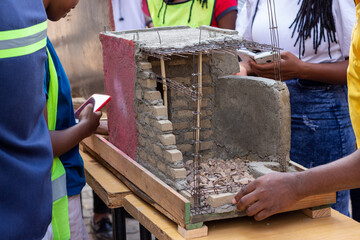 Close-Up of Young Engineers Building Miniature House – Hands-On Civil Engineering Training with Local Materials in Africa