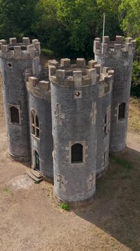 Vertical aerial drone rotation at Blaise Castle, Bristol. Starting level with the turrets, the drone moves upward and right, revealing a shadow extending beside the castle for a striking visual effect