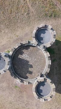 Vertical aerial top-down drone view of Blaise Castle, Bristol, UK. The castle slowly rotates as shadows of its three turrets move clockwise, creating a time-like effect reminiscent of a giant clock.