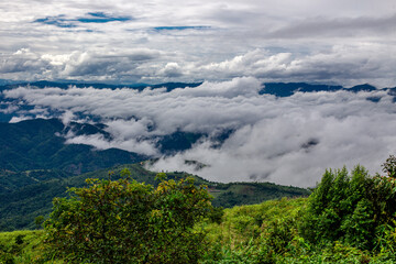 The natural background of the sky above several large mountains, with a view of clouds, trees, mist and a cool breeze blowing throughout the journey.