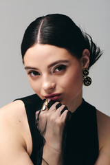 Obraz premium A young woman poses confidently, showcasing her graceful style and fashion sense.