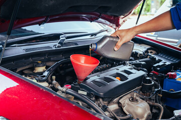 technician changing engine oil and performing vehicle service in a garage, professional auto mechanic work, tools and car parts, clean and organized workshop