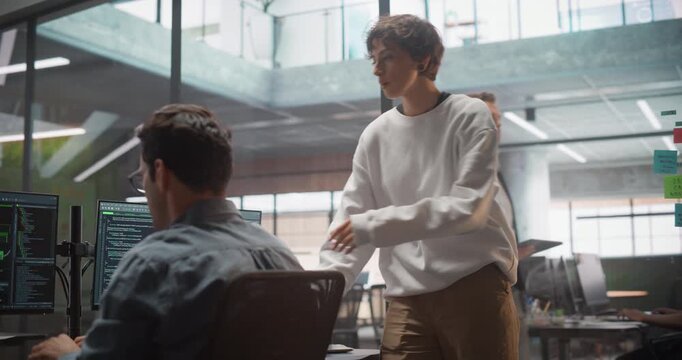 Two Professional IT Programers Discussing Blockchain Data Network Architecture Design and Development Shown on Desktop Computer Display. Male and Female Working in a Technical Department