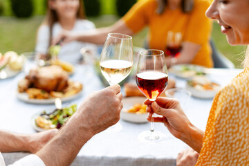 Family toasting with wine glasses at outdoor lunch table selective focus
