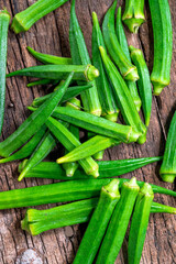 Lady Fingers or Okra over wooden table background. Raw Green Organic Okra Harvest Ready to Cook With. Close up Farm fresh okro on wooden rustic table.