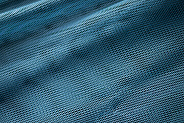 A macro texture background showing a close-up of a blue technical mesh fabric with folds.