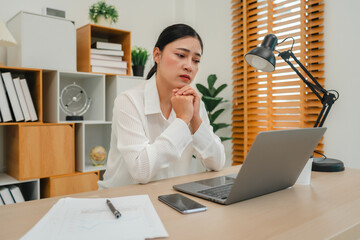 worried woman working with laptop computer at home office