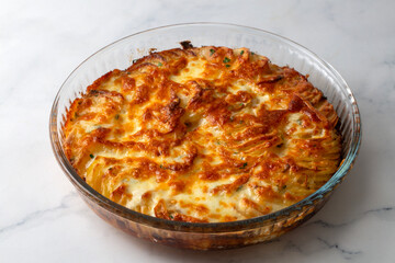 Potato gratin - graten (baked potatoes with cream and cheese) with rosemary and forks (Turkish name; Kremali patates)