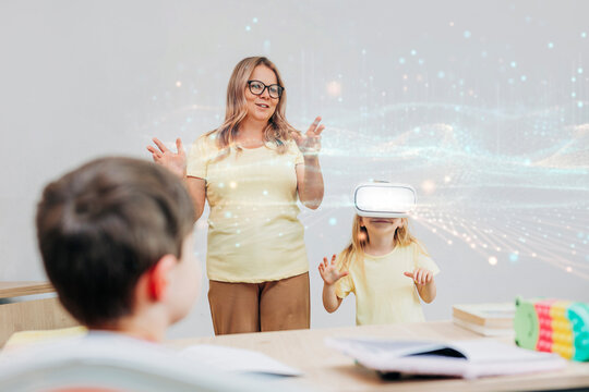 Teacher guiding student using virtual reality in modern classroom