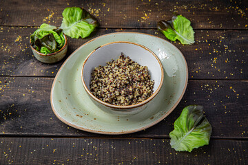 Quinoa porridge in a bowl on rustic brown wooden background. Healthy vegetarian breakfast.